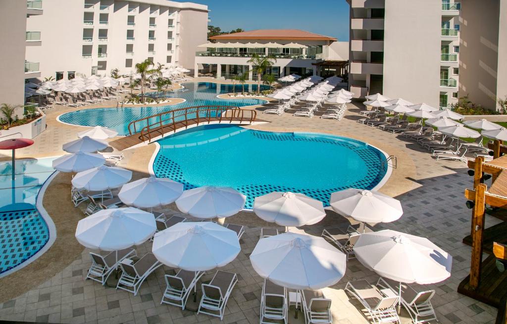 a group of umbrellas and chairs next to a swimming pool at Vangelis Hotel & Suites in Protaras