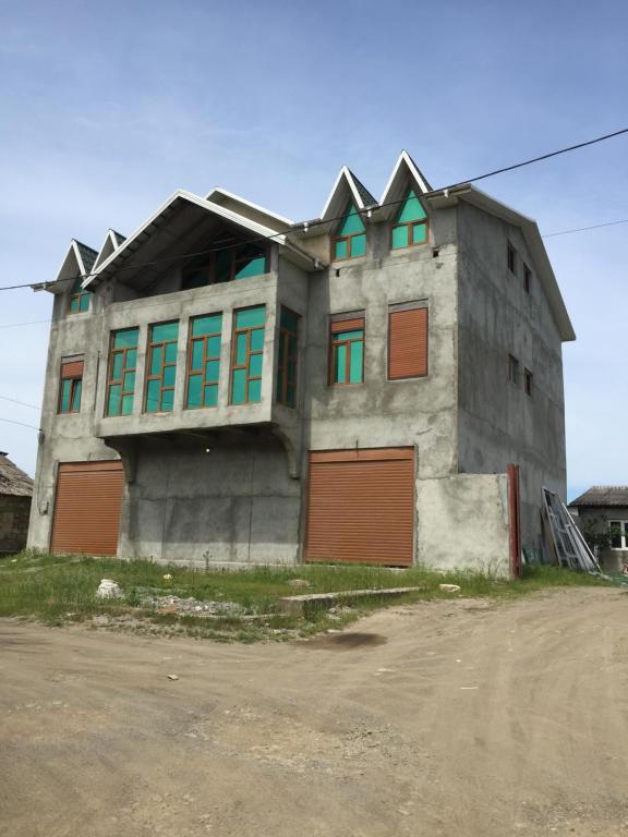 a building with doors and windows on a street at Hostel One in Lankaran