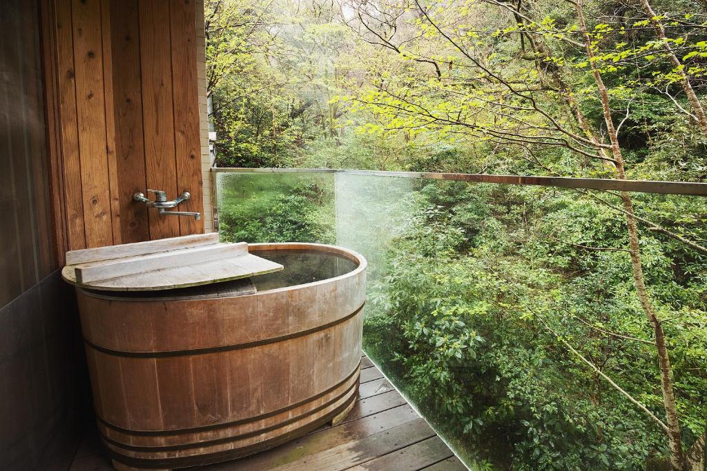 a wooden tub on a deck with a view at Condominium Sakura in Hakone