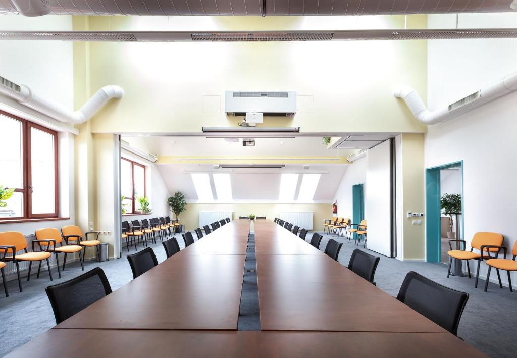 pusta sala konferencyjna z długim stołem i krzesłami w obiekcie Sport relax hotel Na kopečku w mieście Křinec