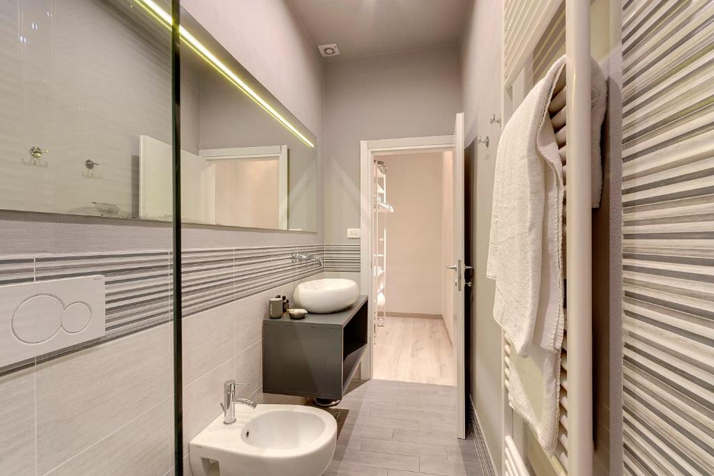 biała łazienka z umywalką i toaletą w obiekcie Courtyard Suite we Florencji