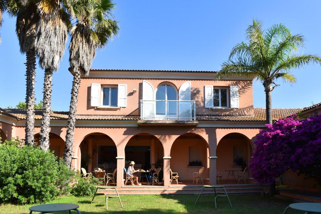 a house with palm trees and a balcony at Résidence les chênes in Borgo