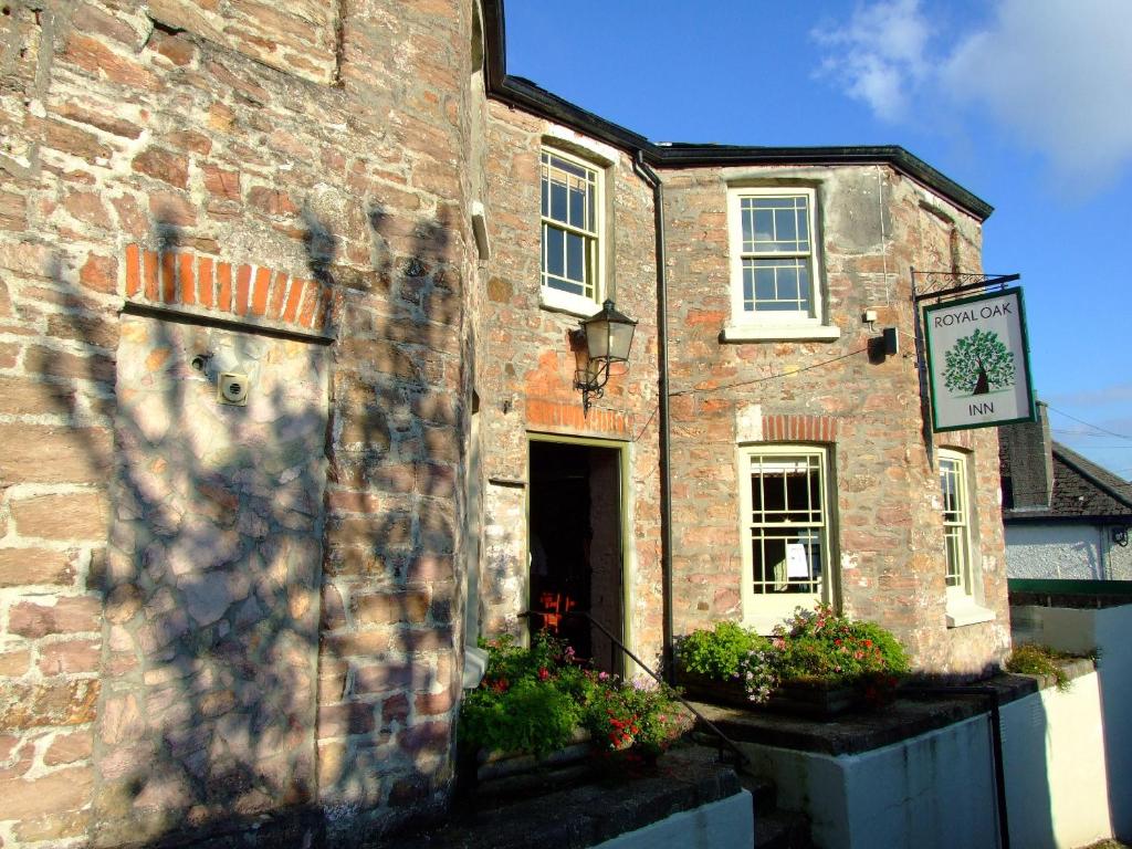 a brick building with a sign on the side of it at Royal Oak Inn in Lostwithiel