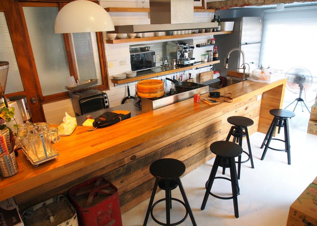 安平的住宿－Jin Flower Homestay，厨房配有带吧台凳的木台