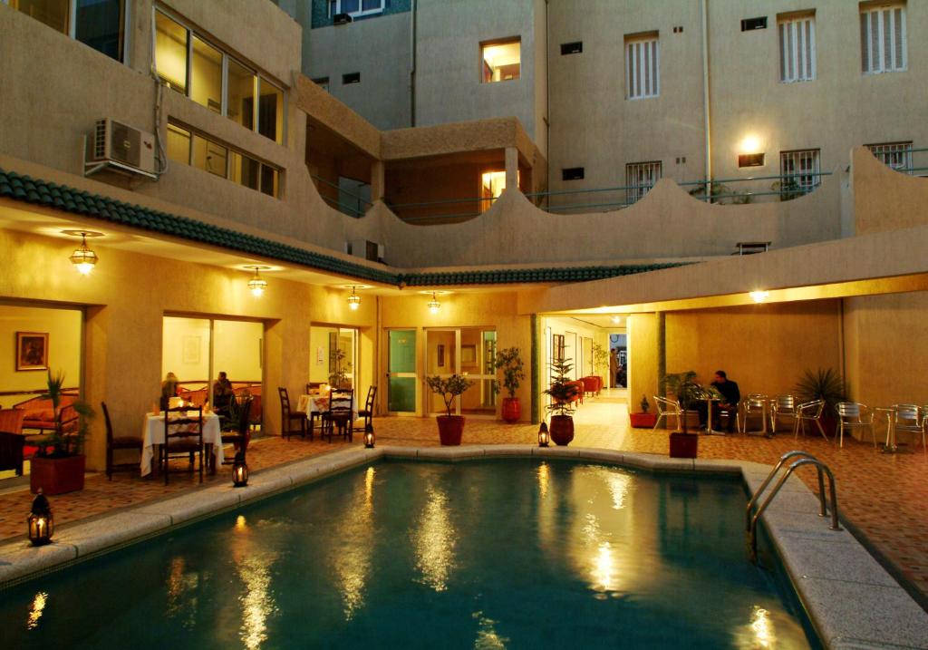 a swimming pool in the middle of a building at Hotel Splendid in Fès