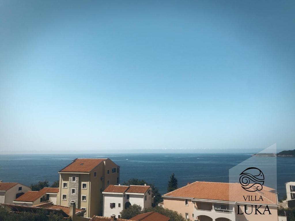 a view of a city with buildings and the ocean at Apartments Villa Luka in Sveti Stefan