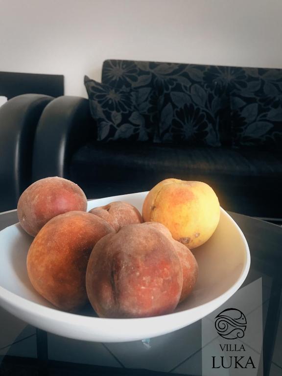 a bowl of peaches and pears on a plate at Apartments Villa Luka in Sveti Stefan