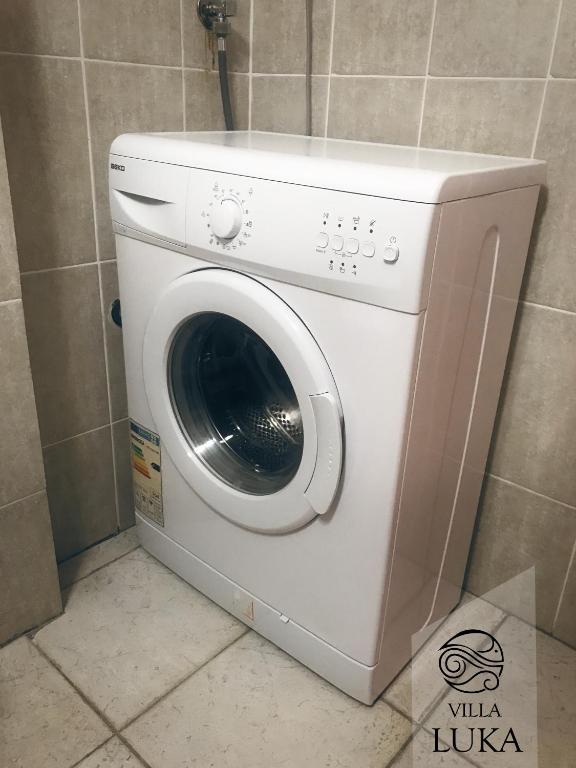 a white washing machine sitting in a bathroom at Apartments Villa Luka in Sveti Stefan