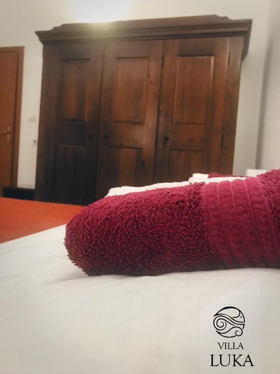 a red pillow sitting on top of a bed at Apartments Villa Luka in Sveti Stefan