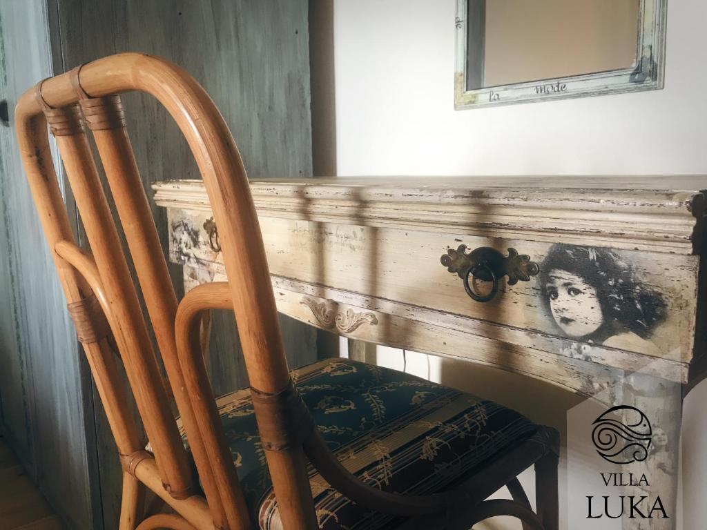 a wooden chair sitting in front of a fireplace at Apartments Villa Luka in Sveti Stefan