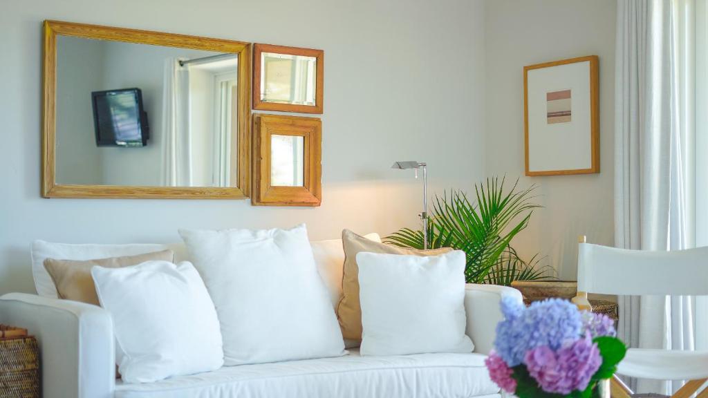 a white couch with pillows in a living room with a mirror at Windward Shores in Amagansett