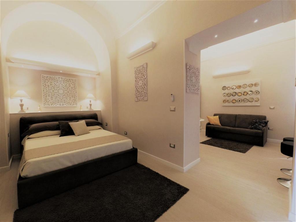 - une chambre avec un grand lit et un canapé dans l'établissement Royal Rooms Luxury Suite, à Naples