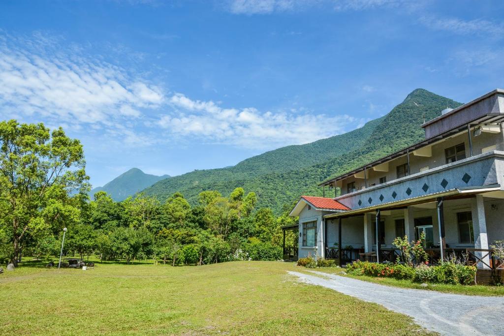 a building with mountains in the background at Taroko Sialin Coffee Farm Homestay in Xiulin