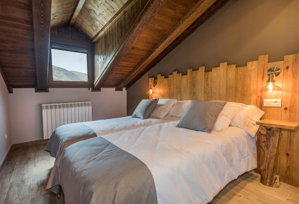 a bedroom with a large bed with a wooden wall at El Puente in Benasque