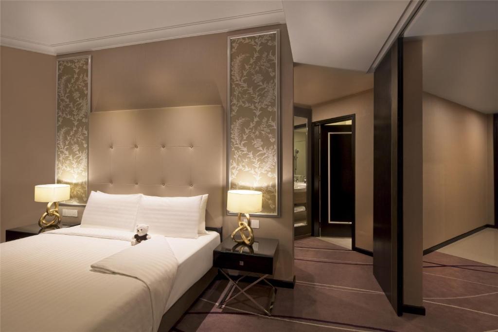 A large bed is shown beside a mirrored wall and the room entrance.