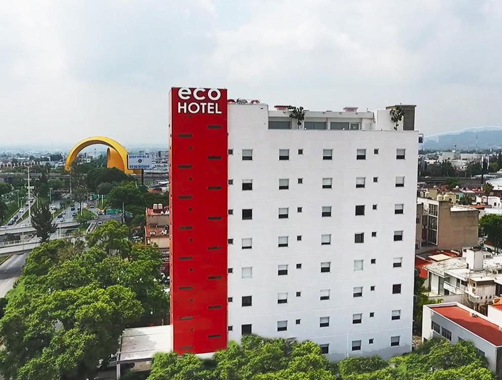 um edifício branco com uma placa de hotel vermelha em Eco Hotel Guadalajara Expo em Guadalajara