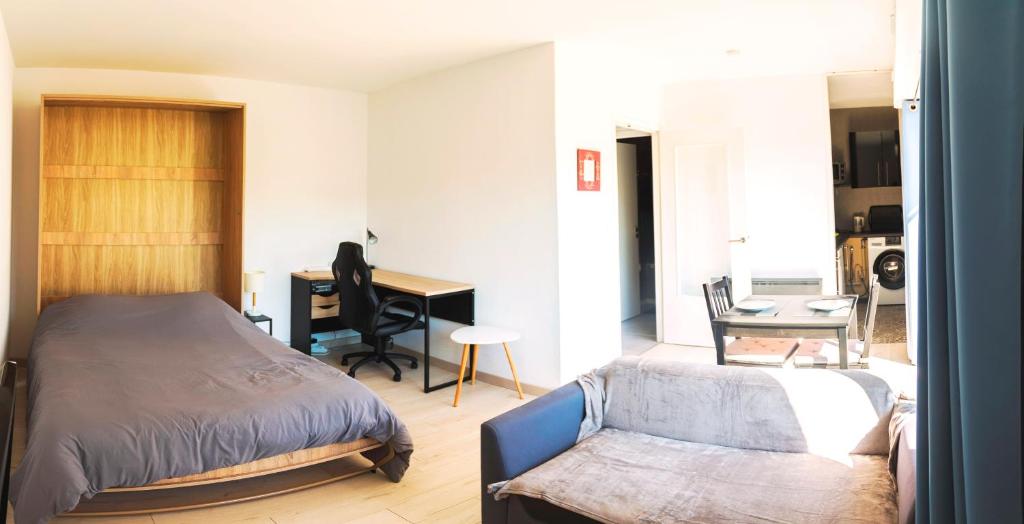 een slaapkamer met een bed en een bureau bij T1 tout équipé avec balcon & parking ! in Cherbourg en Cotentin