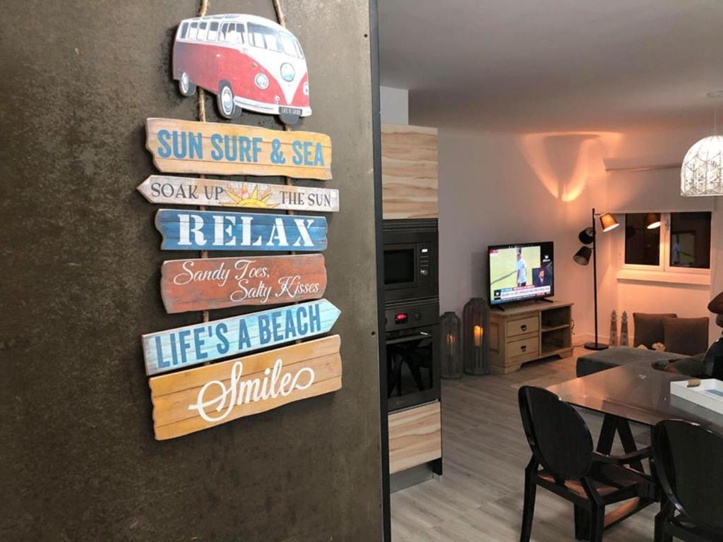 a living room with a sign that reads relax needs a break needs a break at Azores Calheta Inn Apartment T3 in Ponta Delgada