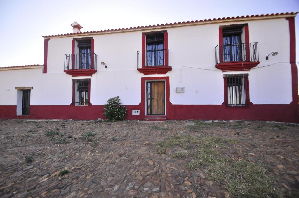 een wit en rood huis met rode ramen bij Casa Rural El Abuelo Alonso in La Codosera