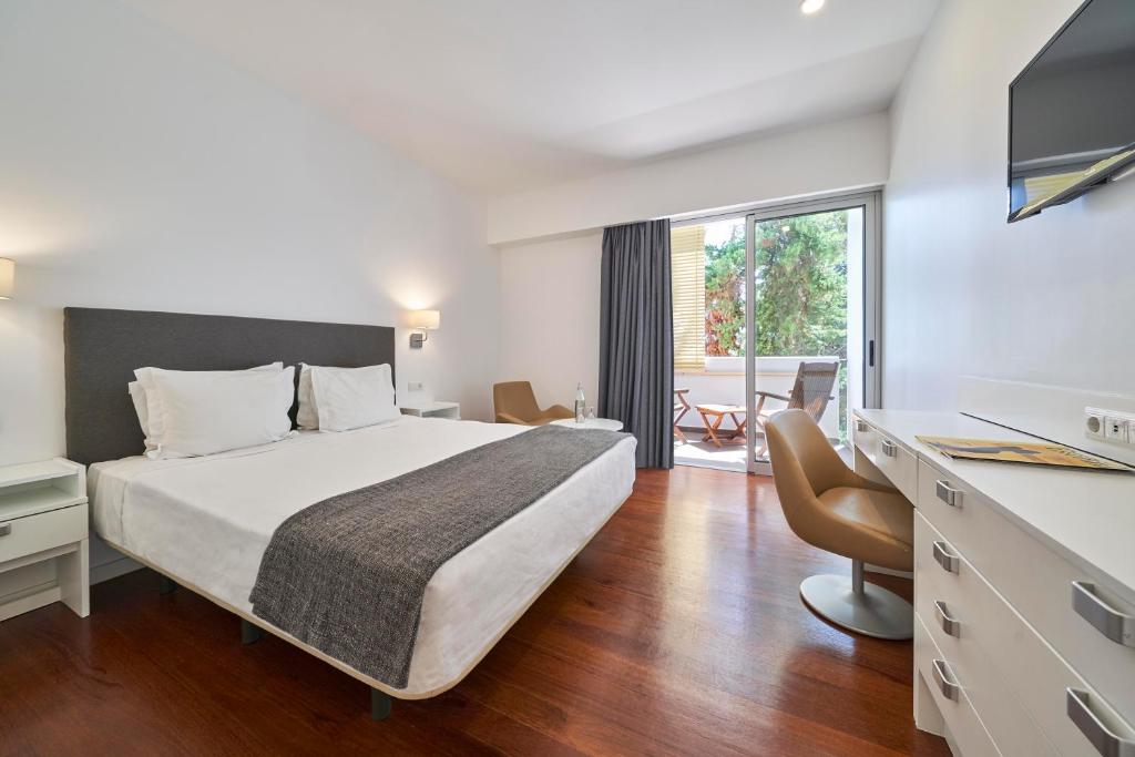 a hotel room with a bed and a large window at Hotel Porto Santo & Spa in Porto Santo