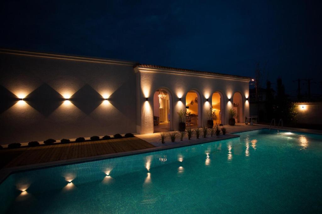 a swimming pool in front of a building at night at Elia Vama Veche (Adults Only) in Vama Veche