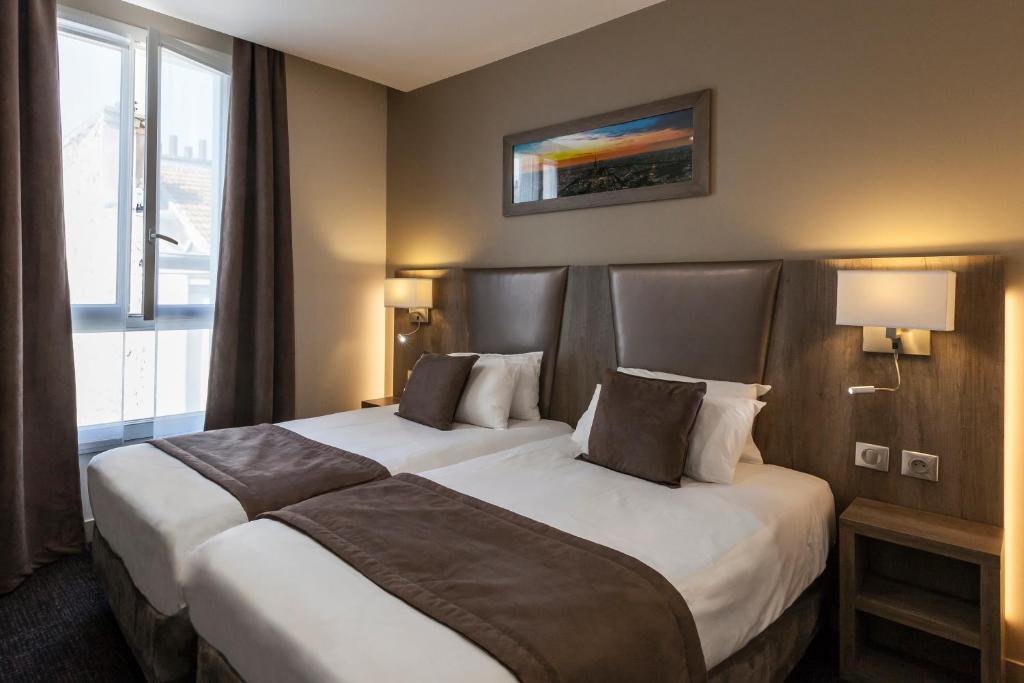 um quarto de hotel com duas camas e uma janela em Hotel Paris Italie em Paris