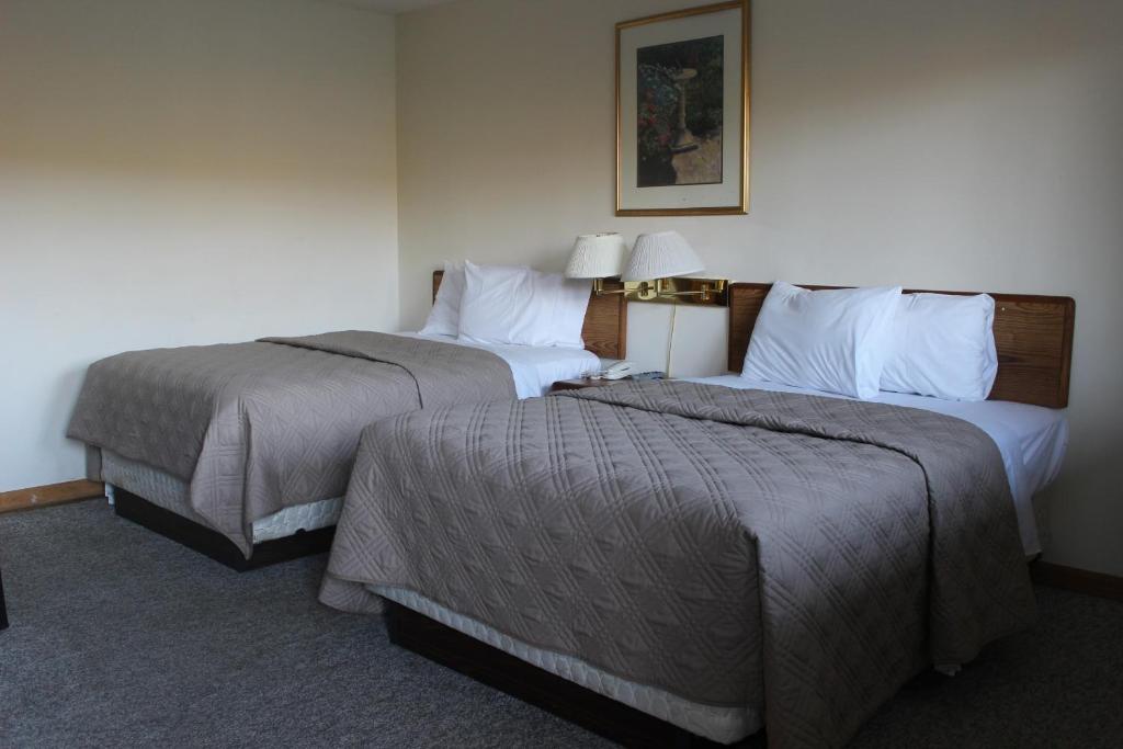 2 Betten in einem nebeneinander liegenden Hotelzimmer in der Unterkunft Berkshire Travel Lodge in Canaan