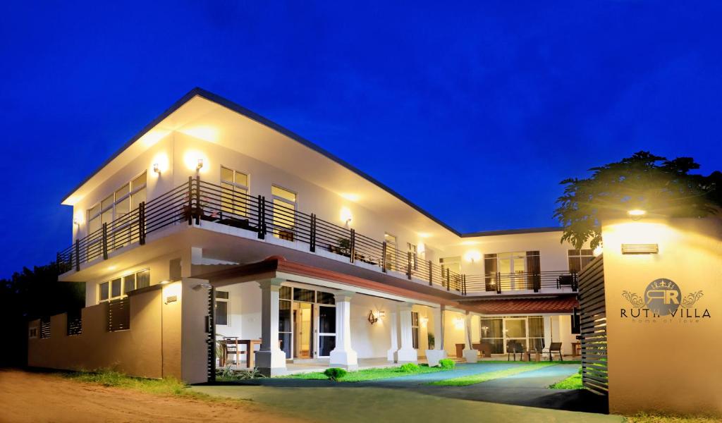 uma grande casa branca à noite com luzes em Ruth Villa em Negombo