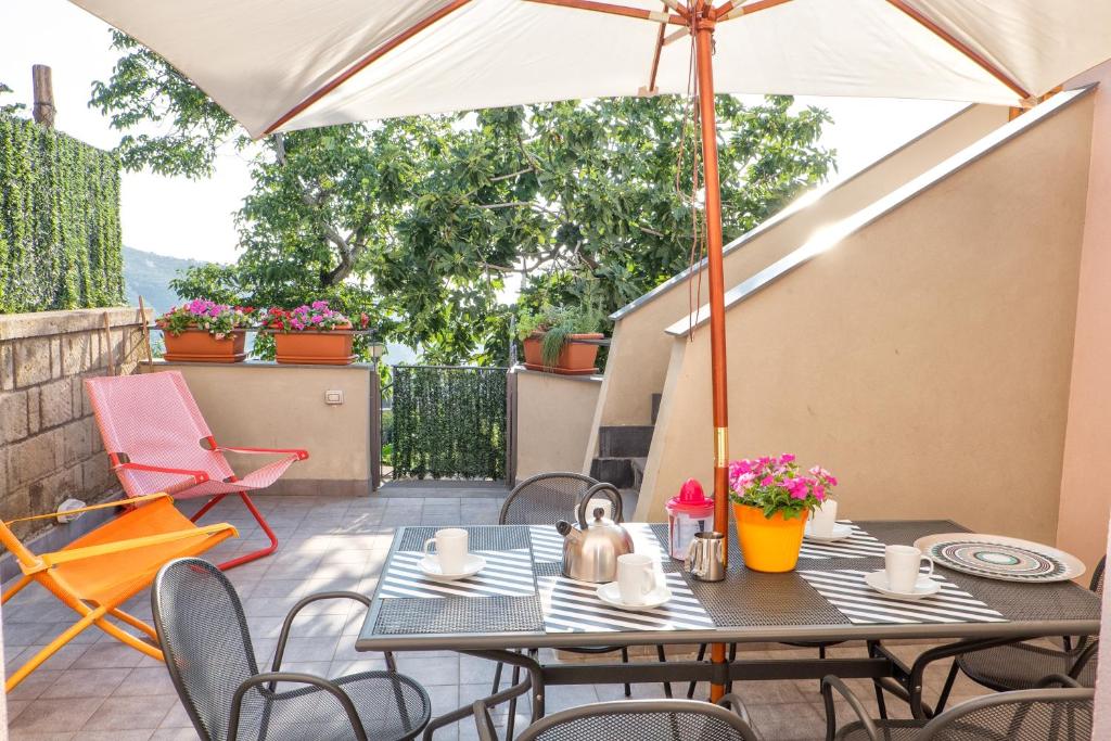 stół z parasolem na patio w obiekcie casa paola w mieście Vico Equense