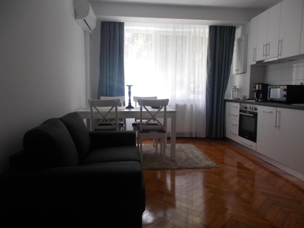 sala de estar con sofá y mesa con sillas en Apartament Luca, en Turda