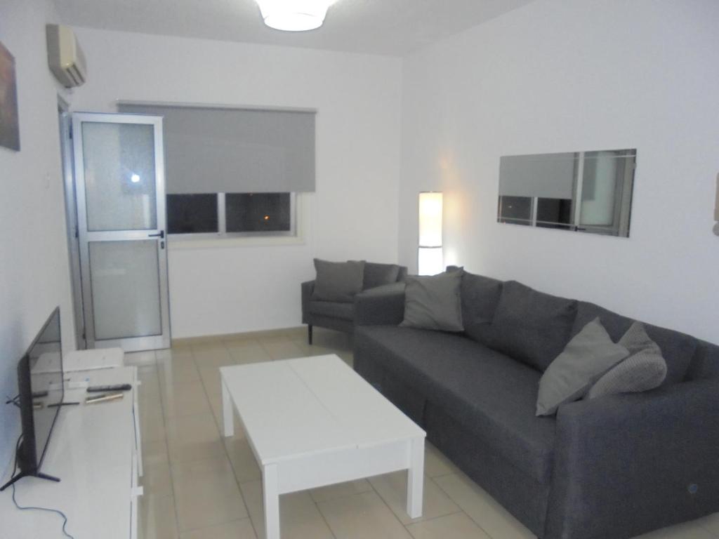 a living room with a couch and a coffee table at Delphi Court - large 1 bed -sleeps 4, Near sea/beach - free wifi in Limassol