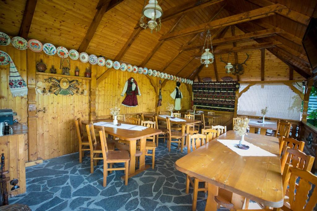 a dining room with wooden tables and wooden chairs at ILEANA Săpânța in Săpânța