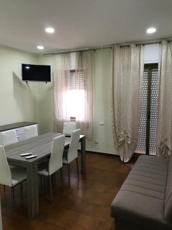 a dining room with a table and white chairs at Residence Lamezia Golfo in SantʼEufemia Lamezia