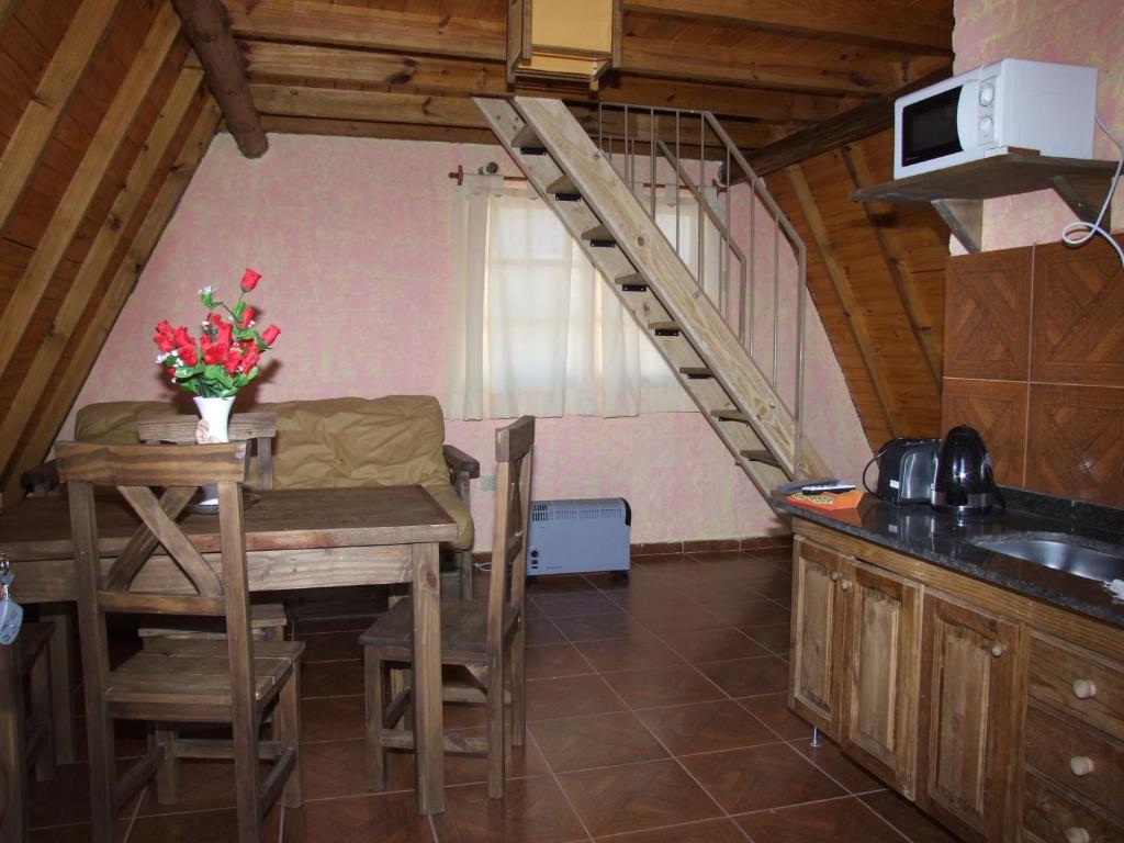 a kitchen with a table and a staircase in a room at Cabañas Wenelcklén in Uspallata