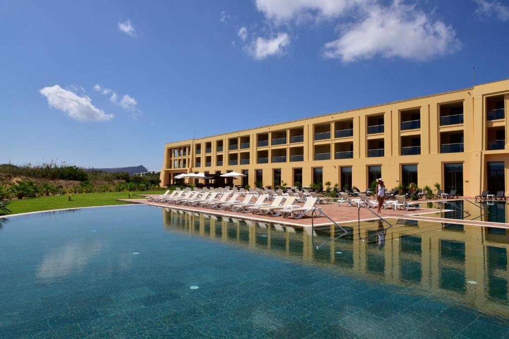 a large building with chairs and a pool of water at Pestana Colombos Premium Club - All Inclusive in Porto Santo