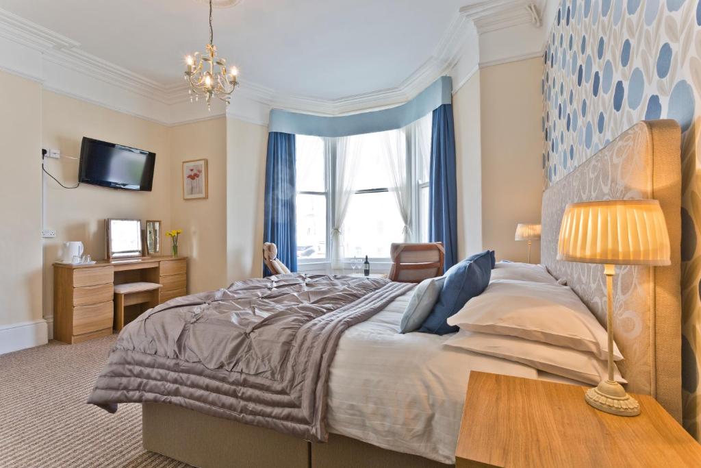 - une chambre avec un grand lit et une fenêtre dans l'établissement The Wilton, à Llandudno