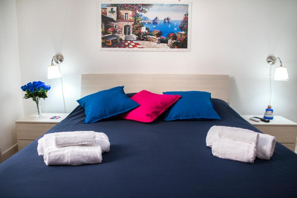 ナポリにあるB&B Carbonara Napoliの青いベッド1台(カラフルなタオル2枚付)