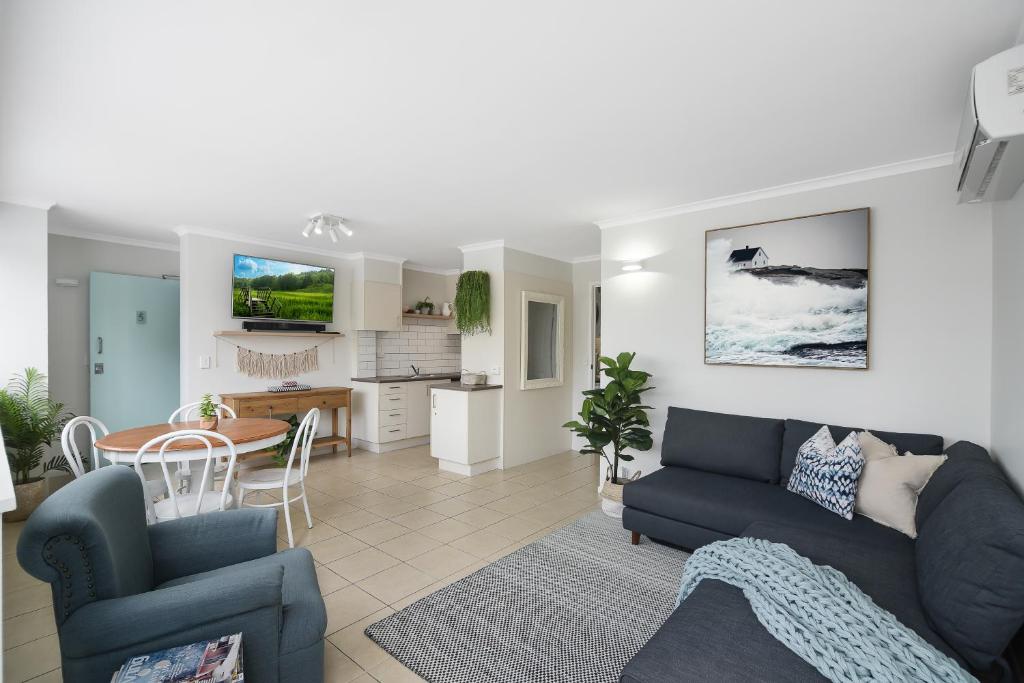 a living room with a blue couch and a table at Renovated Moololaba Unit 100m To Beach in Mooloolaba