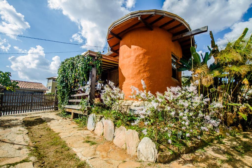 an orange building with a fence in front of it at Bio Chalé Carrancas in Carrancas