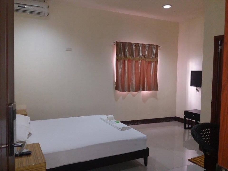 a bedroom with a white bed and a window at Asia Novo Boutique Hotel - Catbalogan in Catbalogan