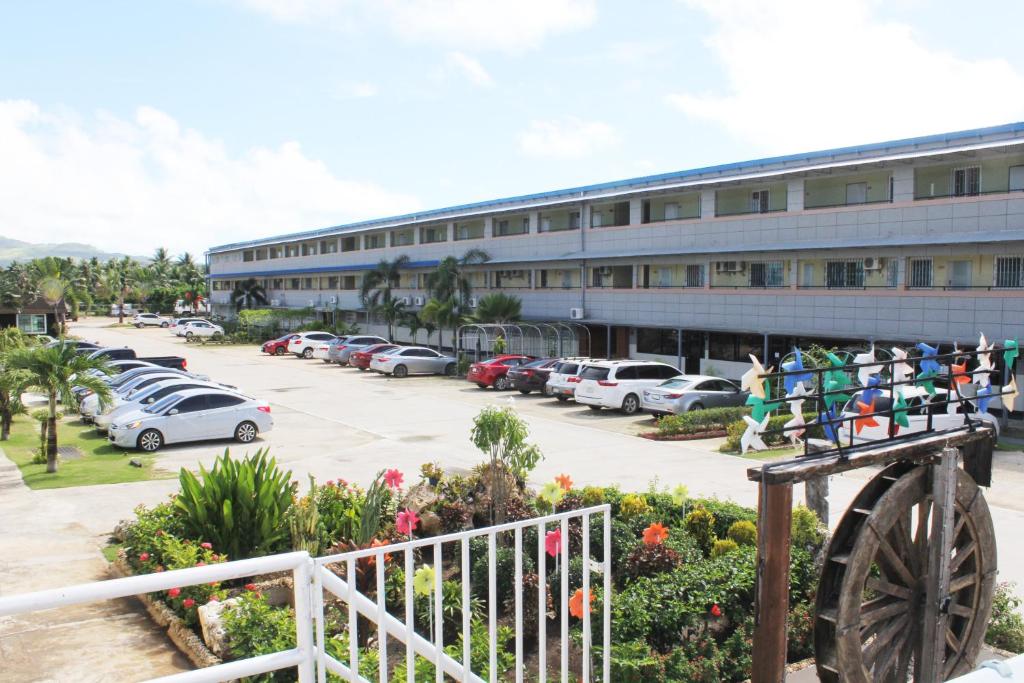 a building with cars parked in a parking lot at Winners Residence in Saipan