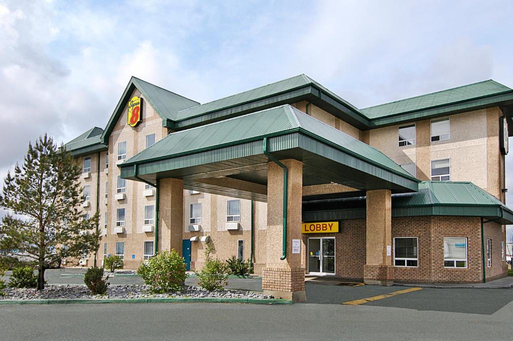 un bâtiment d'hôtel avec un panneau devant lui dans l'établissement Super 8 by Wyndham Edmonton International Airport, à Leduc