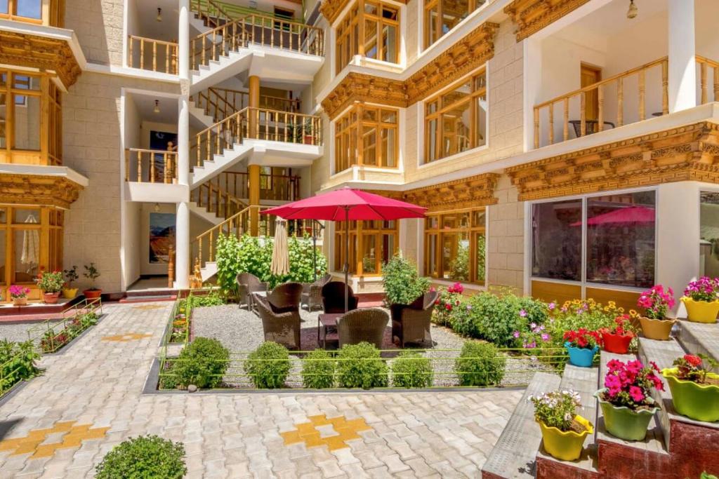 un edificio con un patio con flores y plantas en Hotel Om Ladakh, en Leh