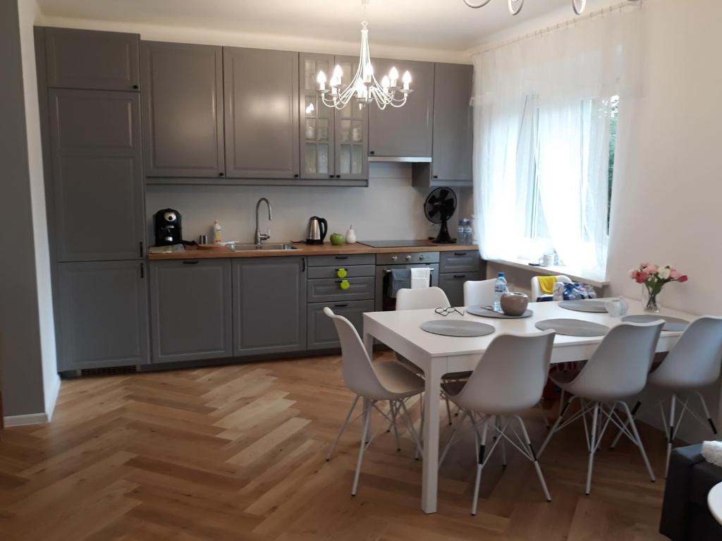 a kitchen with a white table and chairs in a room at 2 Bedroom City Center Apartment in Katowice