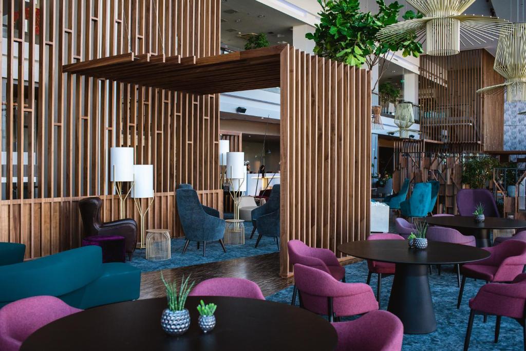 
a living room filled with tables and chairs at Radisson Blu Hotel Lietuva in Vilnius
