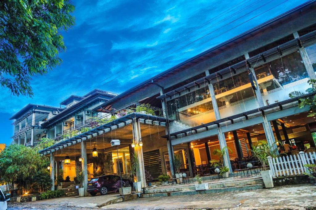 un gran edificio con un coche aparcado delante de él en Oak Ray Ella Gap Hotel, en Ella