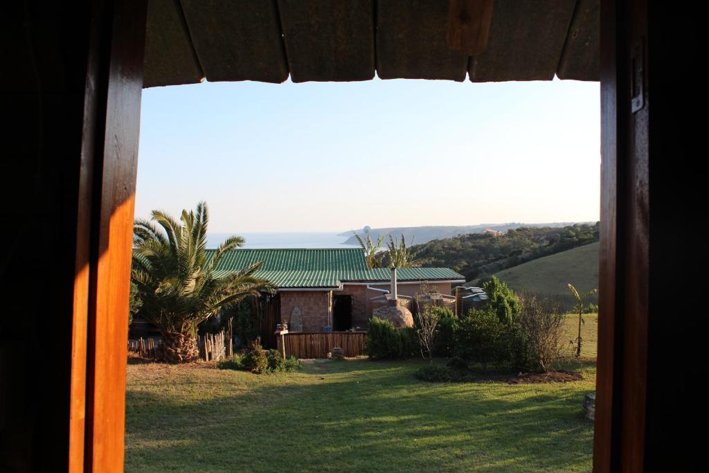 a view from a window of a house with a yard at The Wild Farm Backpackers in Wilderness