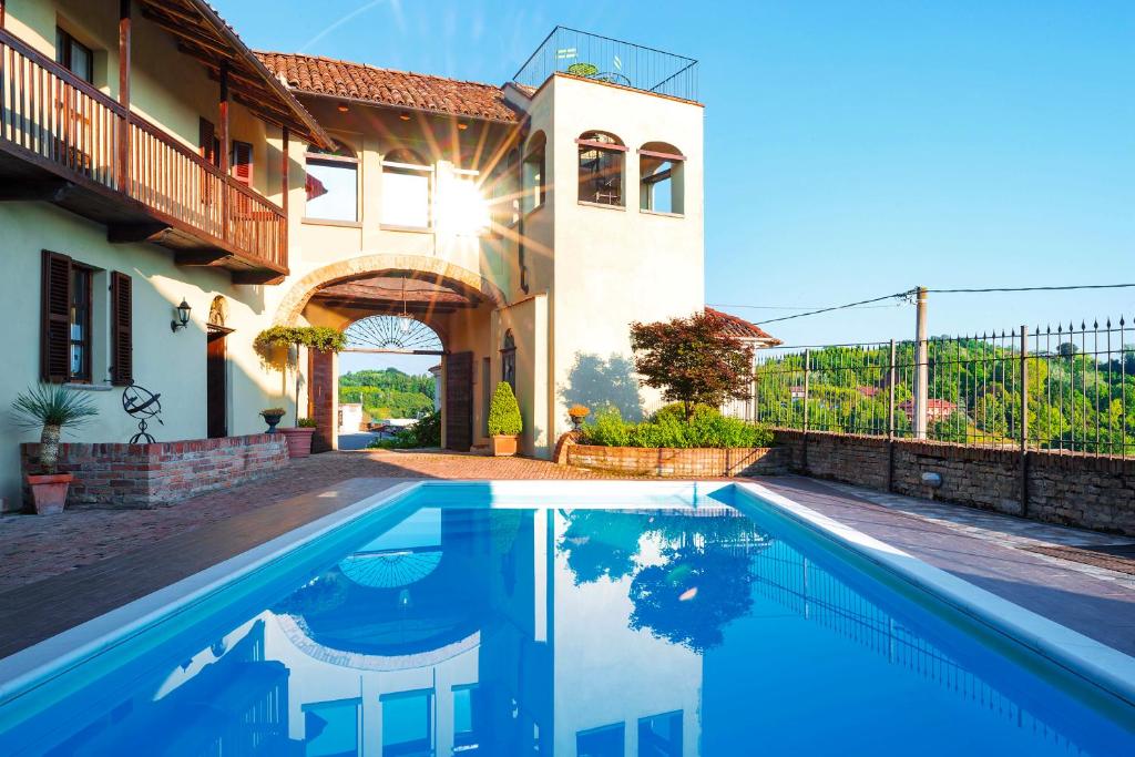 a villa with a swimming pool in front of a house at La Dolce Vite in Tonco