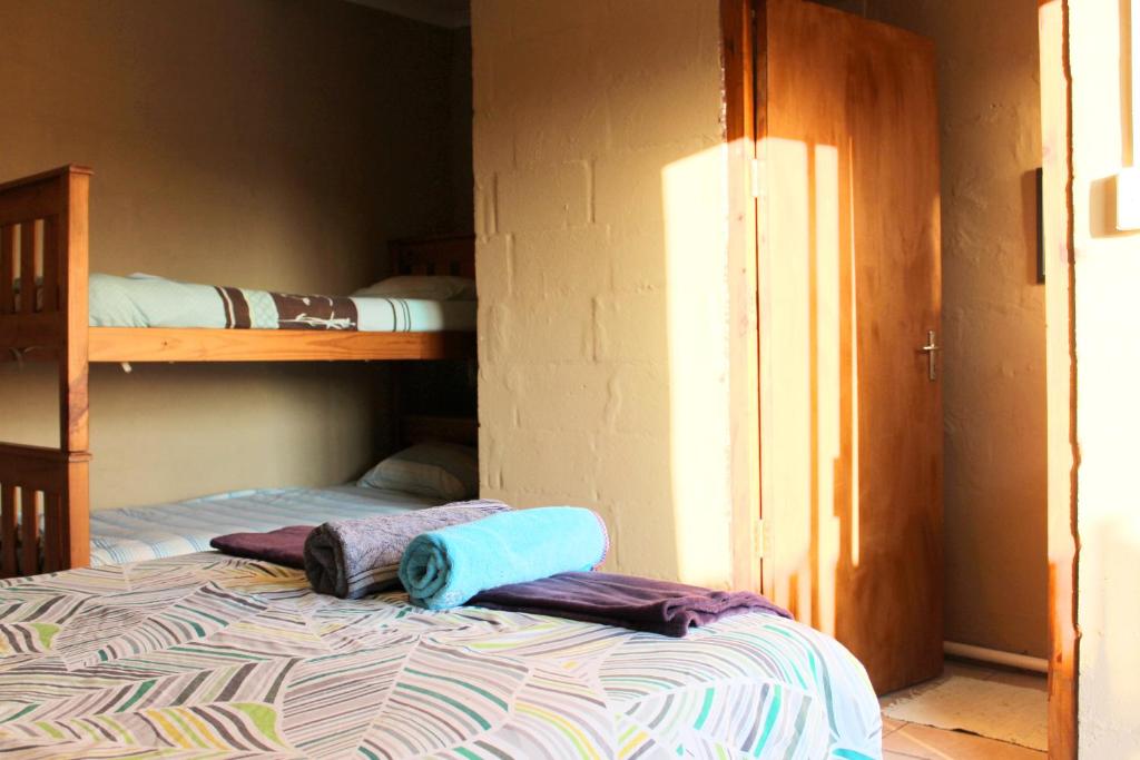 a bedroom with two bunk beds and a bed with a pillow at The Wild Farm Backpackers in Wilderness