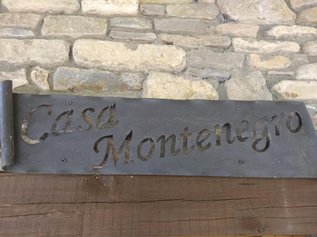 Una señal que dice "eminencia monárquica" delante de una pared de piedra. en Casa Montenegro en Las Colladas